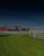Photograph of a farm with a white fence